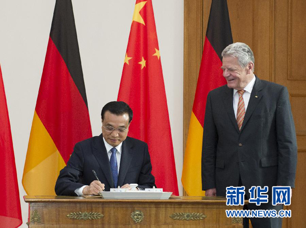 10月10日，國務院總理李克強在柏林會見德國總統高克。這是李克強總理在高克總統的陪同下在貴賓簿上簽字。 新華社記者 王曄 攝 